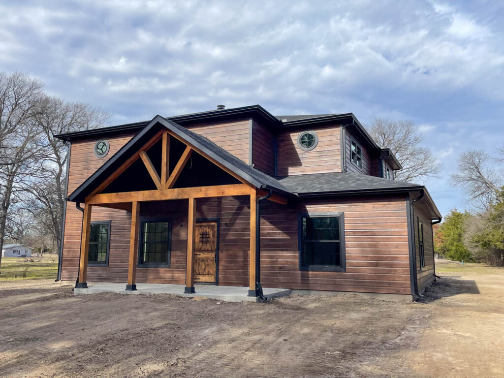 Two-story cedar-sided home with a timber-framed front porch