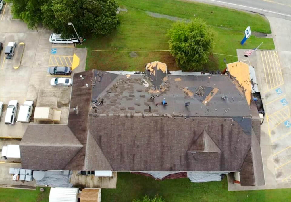 Aerial view of a residential roof tear-off in progress