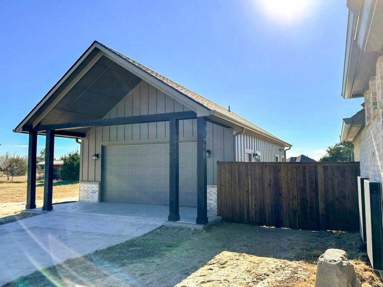 Detached garage with a gabled covered entry and cedar fence