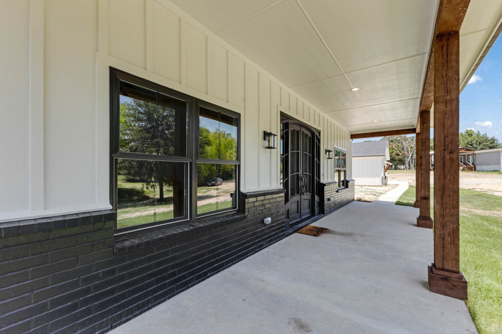 Covered back porch with cedar posts and black board-and-batten wainscot