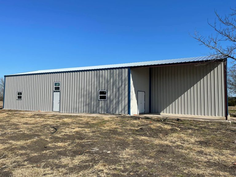 Gray metal building with an attached open-sided equipment shed