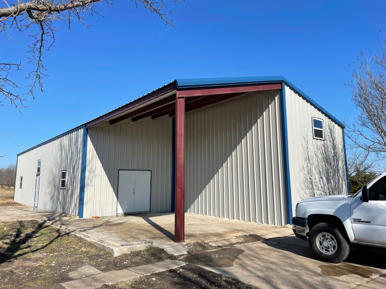 Metal shop building with a red-trimmed lean-to carport