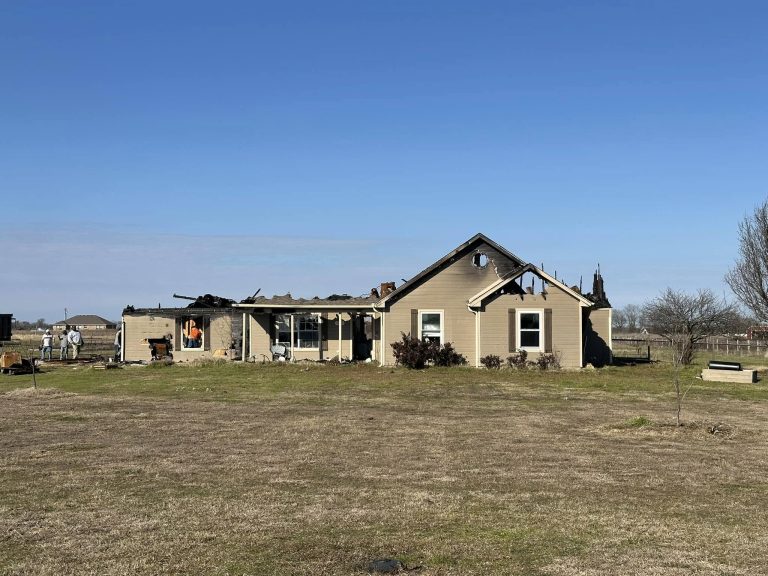 Brick home with a fire-damaged section awaiting restoration