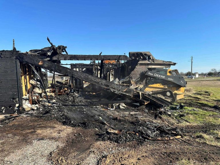 Fire-damaged home being cleared by heavy equipment before rebuilding