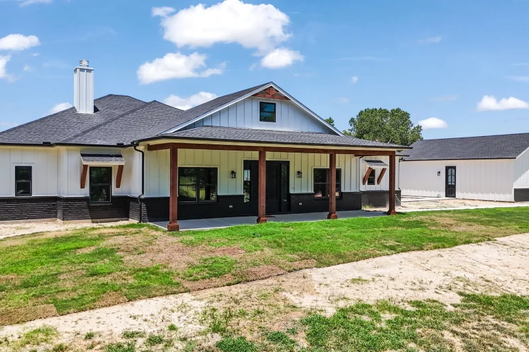 Back of the Adams modern farmhouse in Quinlan with a covered porch