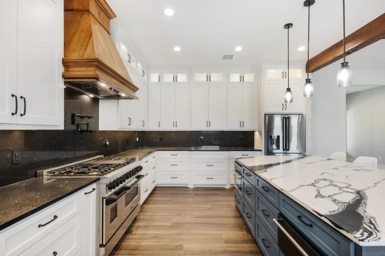 Kitchen with white cabinets, copper range hood and marble-look island