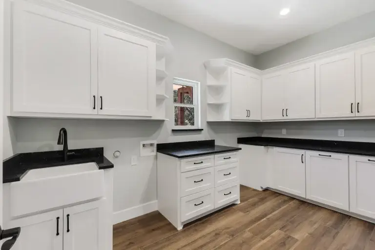 Laundry room with farmhouse sink and white cabinets