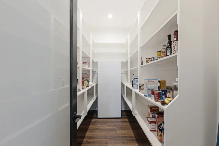 Walk-in pantry stocked with built-in shelving