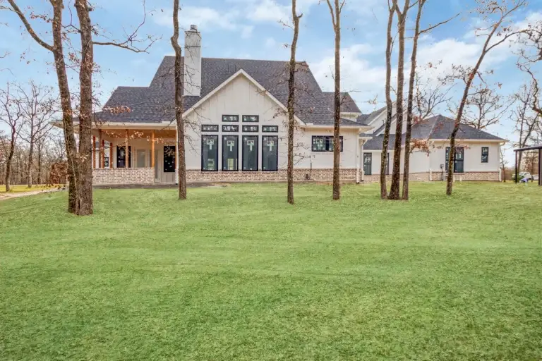 Back of the farmhouse with tall windows and a covered porch