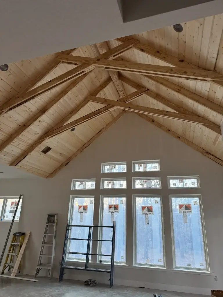 Vaulted wood-plank ceiling with exposed trusses and tall windows
