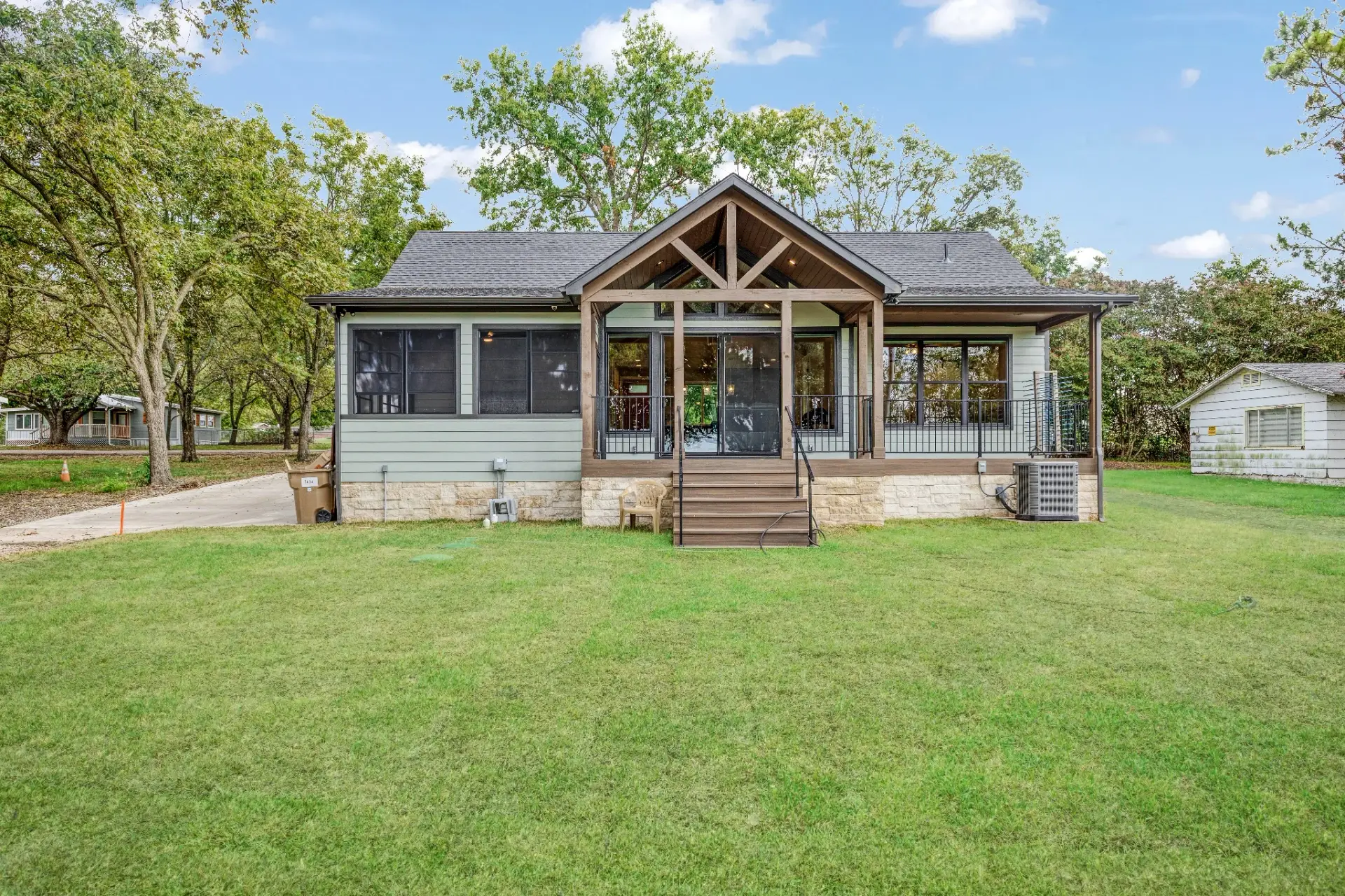 Back of the cottage with a timber gable porch and wide lawn
