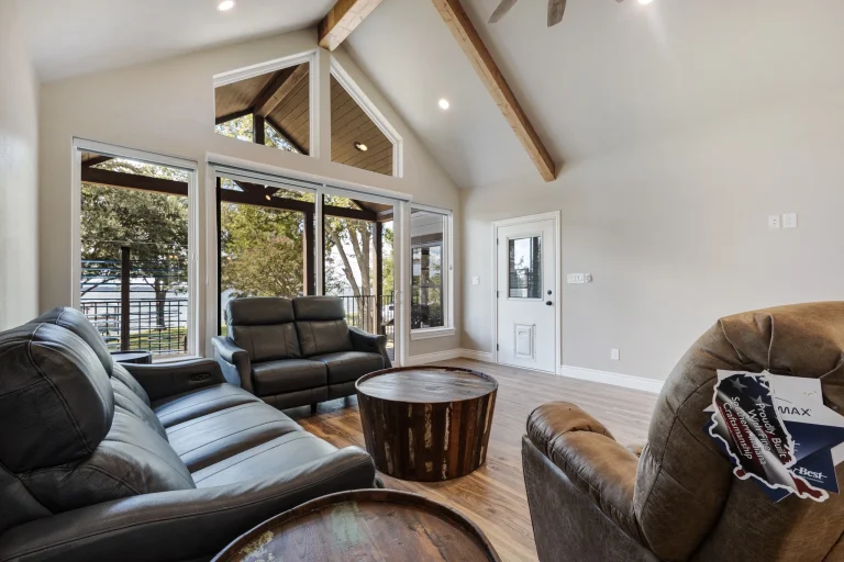 Vaulted great room with exposed beams and gable windows