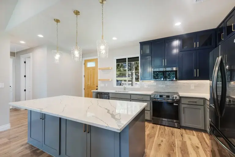 Kitchen with navy cabinets and a marble-look quartz island